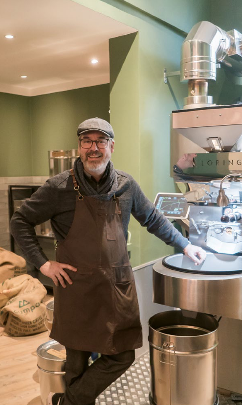 Der Cafebetreiber Jens Haltermann steht neben seinem Tresen im Café Glücksbohne.