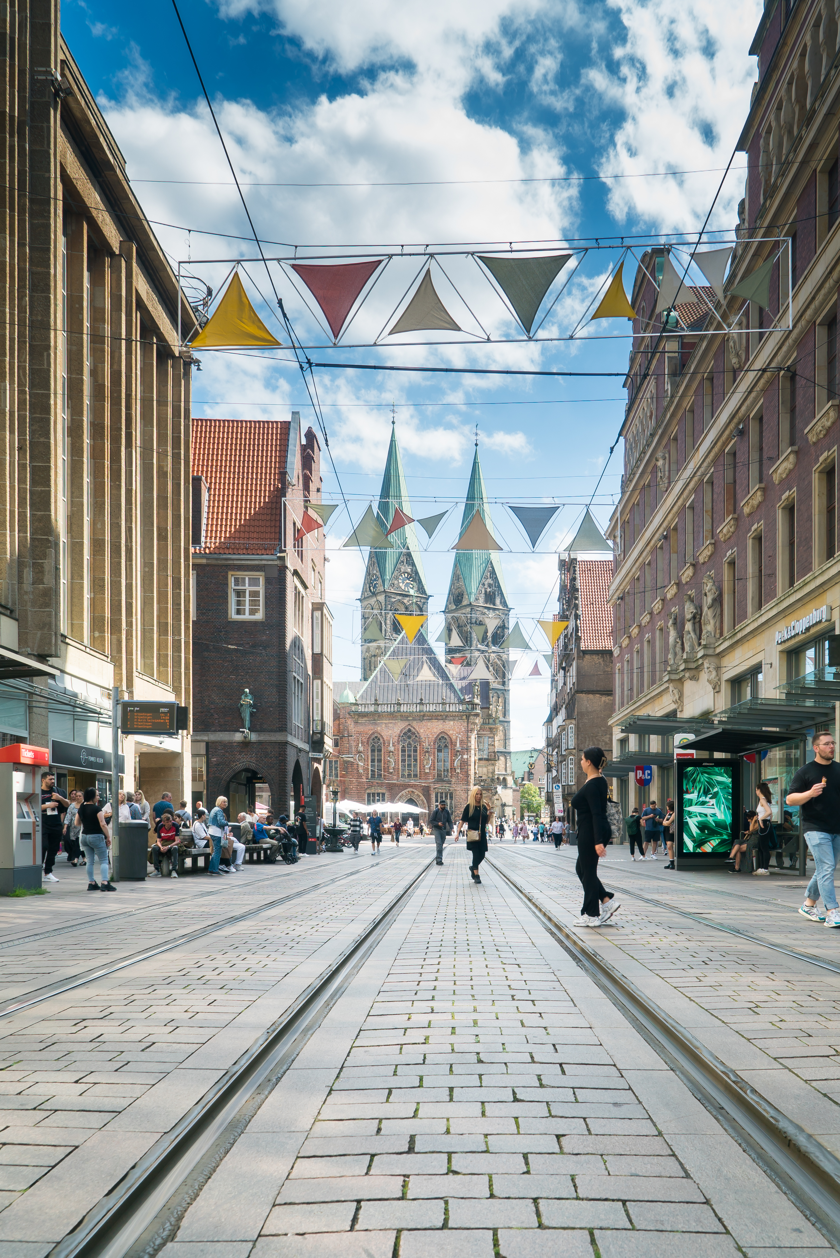 Die Obernstraße im Zentrum von Bremen mit Geschäften links und rechts, dem Dom im Zentrum und einer bunten Girlande über der Straße.